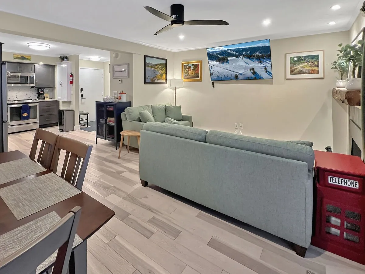 This image captures an open-concept space with a sofa, a dining table that seats several, and a TV as focal points. The arrangement promotes interaction, and the overall atmosphere is both comfortable and welcoming, ideal for dining, relaxation, and socializing.
